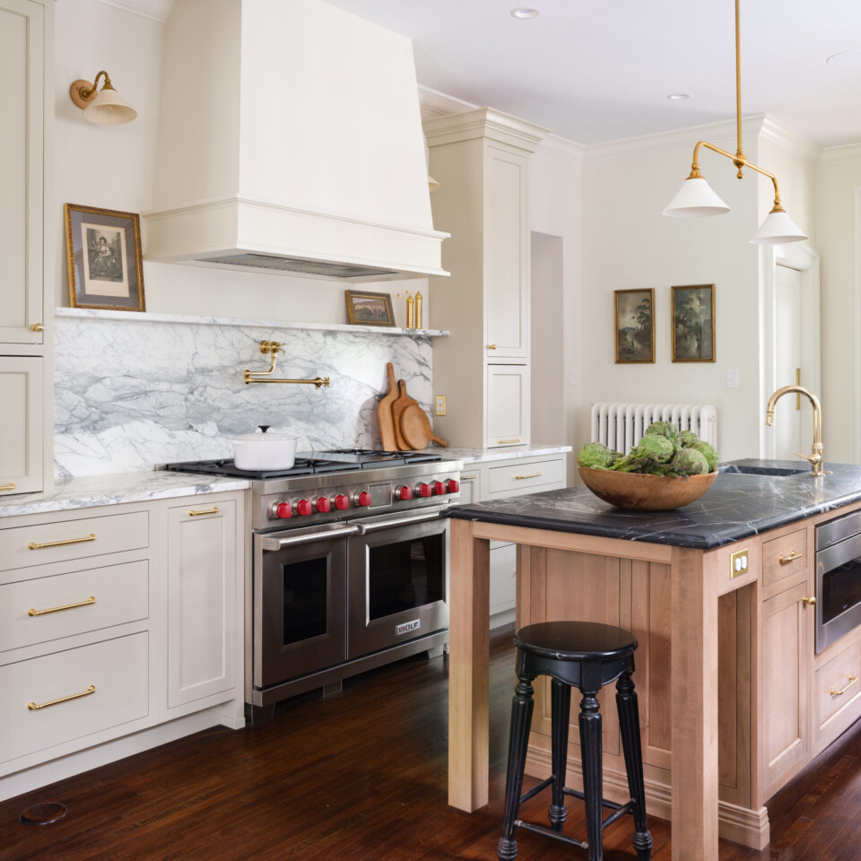 Created by Karr Bick - Photo by Lisa Mitch Door Style/Colors: Olympia Door Style perimeter in Painted Maple Match to Farrow & Ball “Old White”, Island is Select Alder Cognac